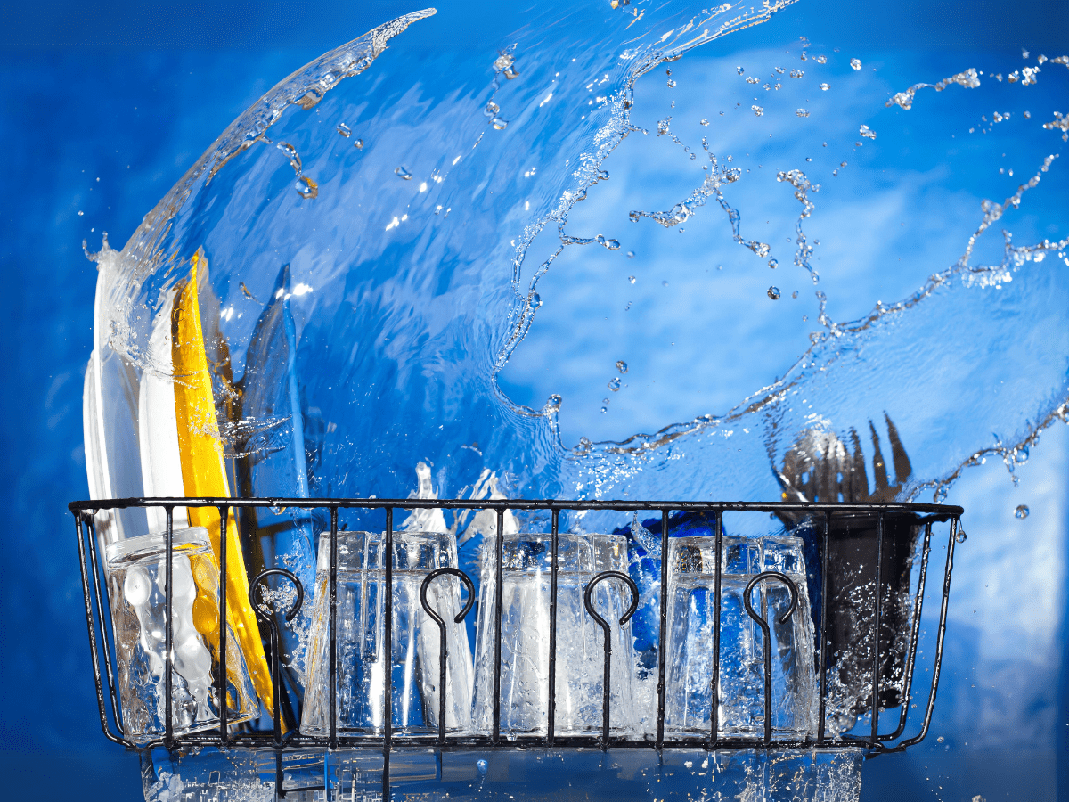 Commercial dishwashers in action with water splashing, showcasing efficient and powerful cleaning performance