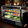 Salad bar fridge filled with fresh vegetables and assorted meats, neatly organized in trays.